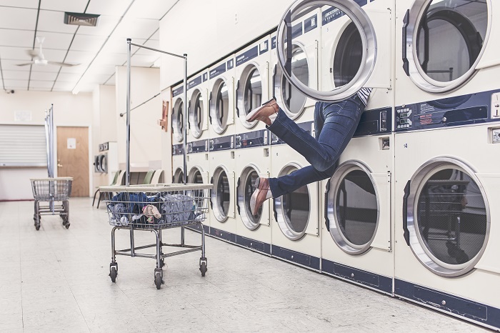 photo; person lost in a dryer at the laundromat